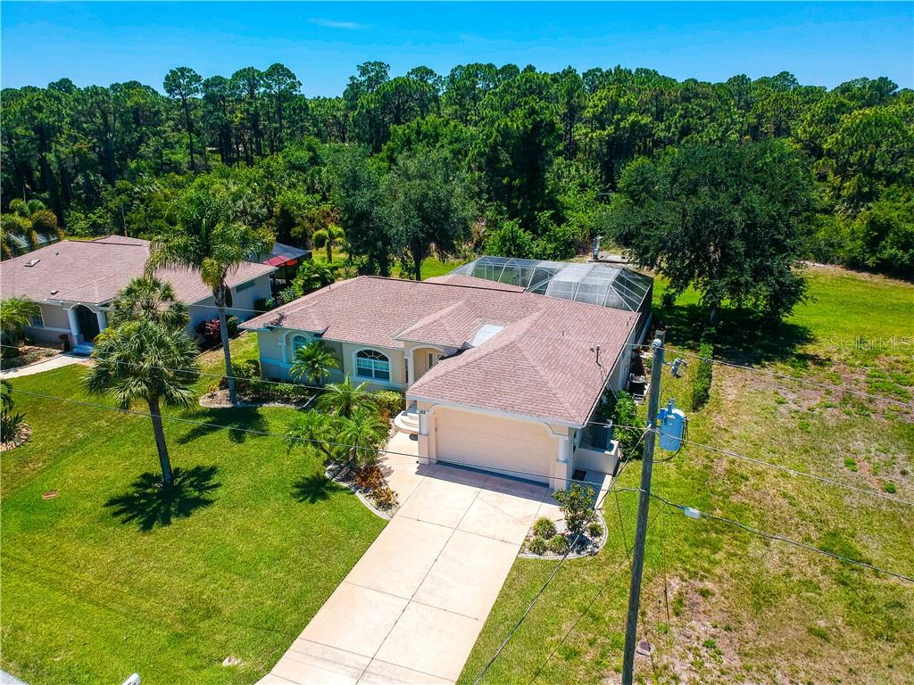 An aerial view of a single-story house with a two-car garage and a screened pool — 155 LONG MEADOW LANE, ROTONDA WEST, FL