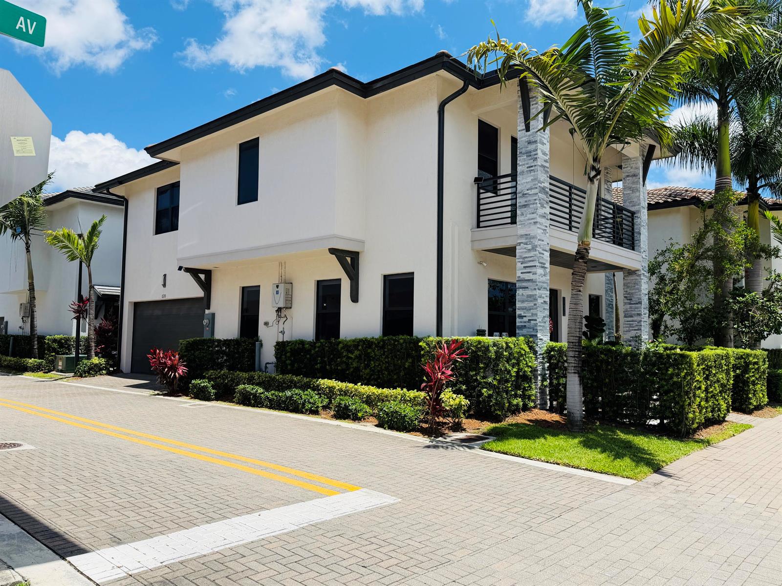 A two-story stucco house with a garage, balcony, and stone-accented columns sits on a paved street — 8288 NW 44th Terrace, Doral FL 33166, DORAL, FL