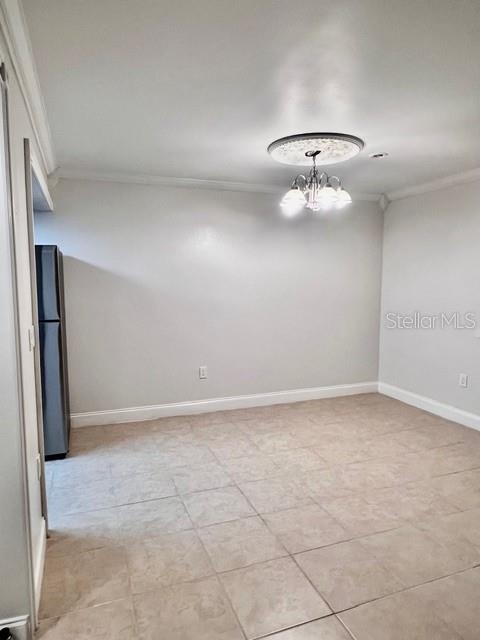 A dining area features light-colored tile flooring, a decorative ceiling light fixture, and a refrigerator — 942 LAKE DESTINY ROAD UNIT A, ALTAMONTE SPRINGS, FL
