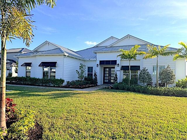 A white, single-story house with a metal roof and palm trees in the front yard — 20076 SE Bridgewater Drive, Jupiter FL 33458, JUPITER, FL