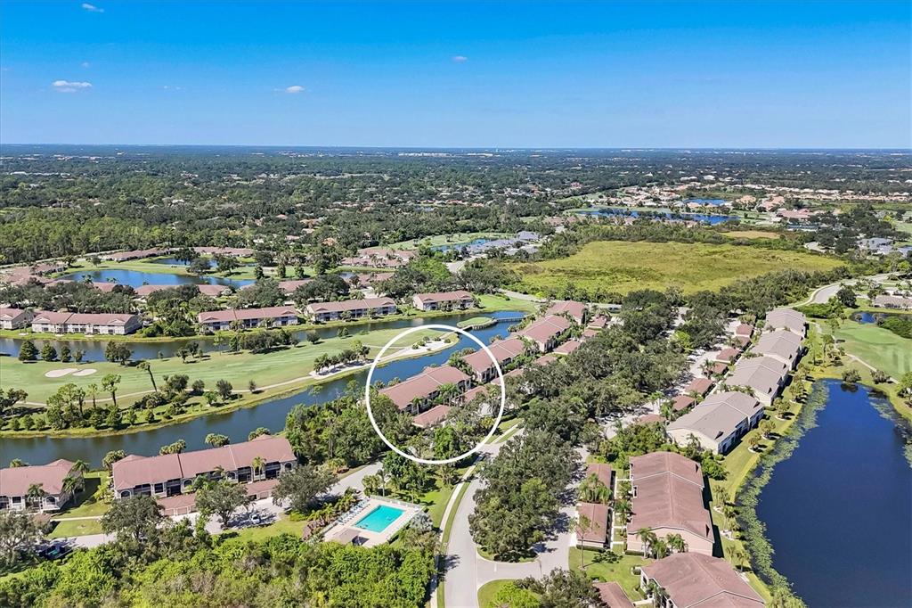An aerial view shows a residential complex with multiple buildings, ponds, and a golf course — 5240 HYLAND HILLS AVENUE UNIT 1426, SARASOTA, FL