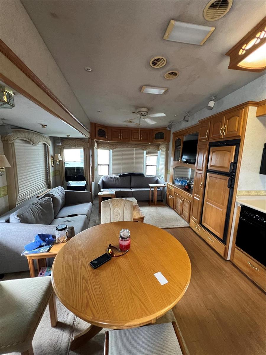 An interior view of a recreational vehicle living area with a dining table and sofas — 5355 SE 64th Terrace, Okeechobee FL 34974, OKEECHOBEE, FL