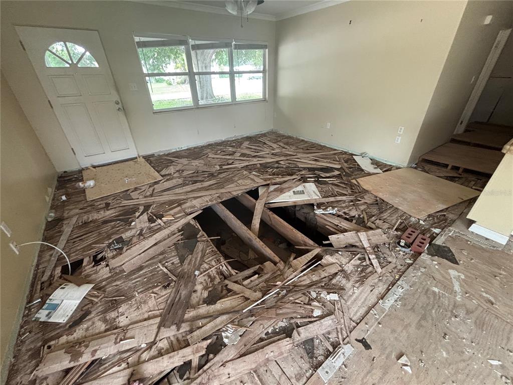 A room with a large hole in the subfloor exposing the crawl space below — 5620 2ND AVENUE DRIVE W, BRADENTON, FL
