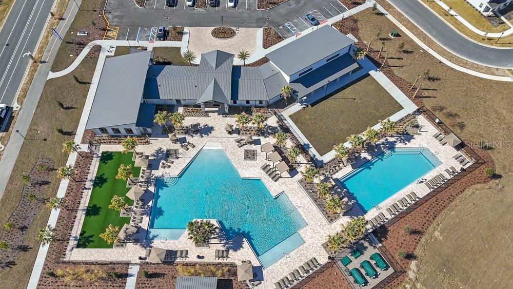 An aerial view shows a community clubhouse with two swimming pools and surrounding lounge areas — 2841 HAZE ROAD, CLERMONT, FL