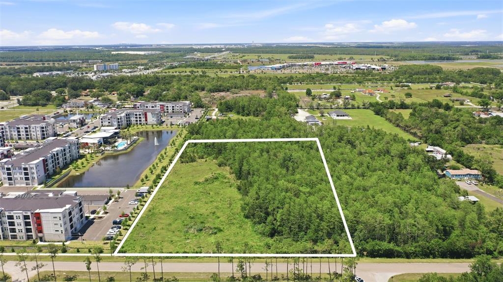 An aerial view shows a rectangular plot of land outlined in white near apartment buildings — 6385 BETH ROAD, ORLANDO, FL