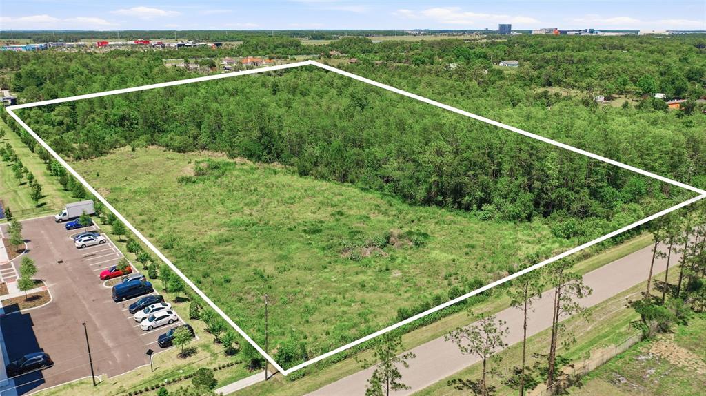 An aerial view shows a large, rectangular plot of undeveloped land outlined in white — 6385 BETH ROAD, ORLANDO, FL