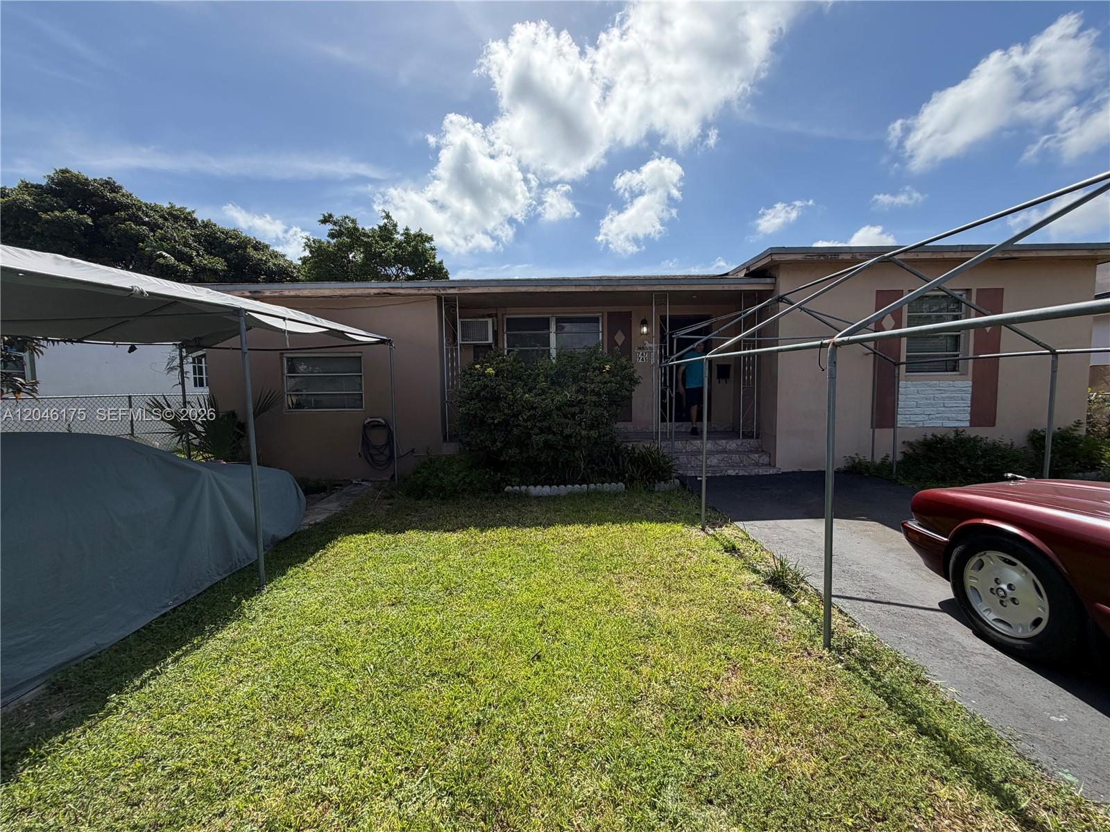 A single-story house features a front lawn, two metal carports, and a paved driveway — 745 NW 32nd Ave, Miami FL 33125, MIAMI, FL