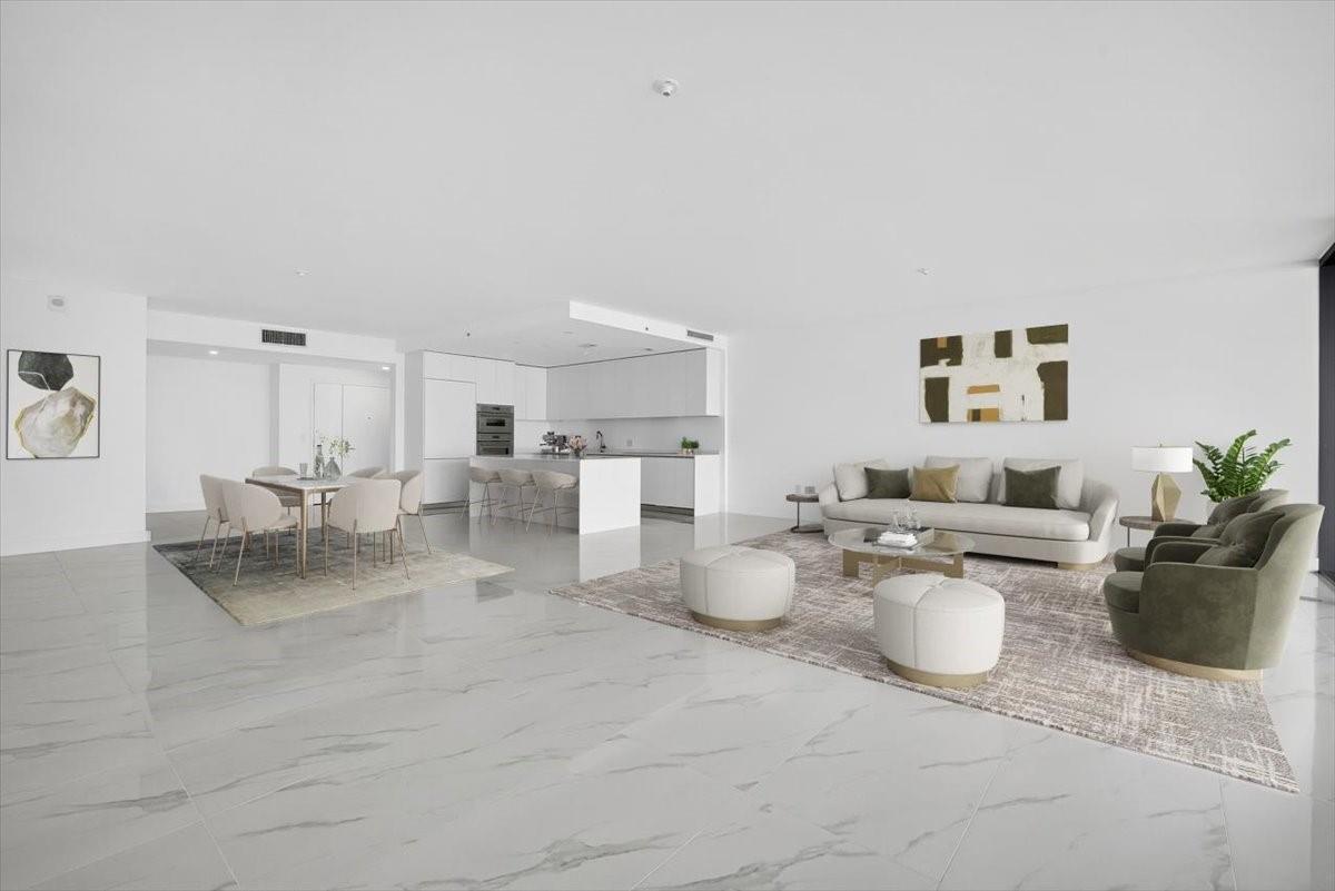A modern, open-concept living and dining area features white marble floors and minimalist white cabinetry — 700 NE 24th Street # 5202, Miami FL 33137, MIAMI, FL
