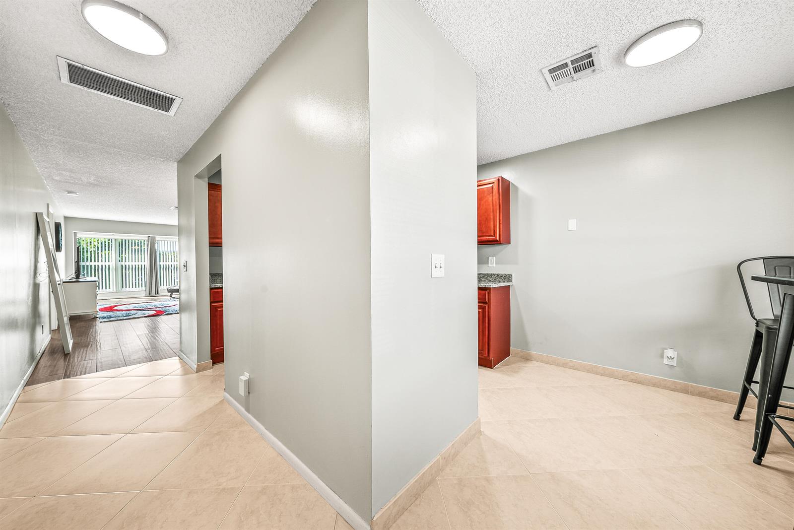 A view of a kitchen area with tile flooring, light gray walls, and cherry-wood cabinets — 1640 NW 19TH Terrace # 203, Delray Beach FL 33445, DELRAY BEACH, FL