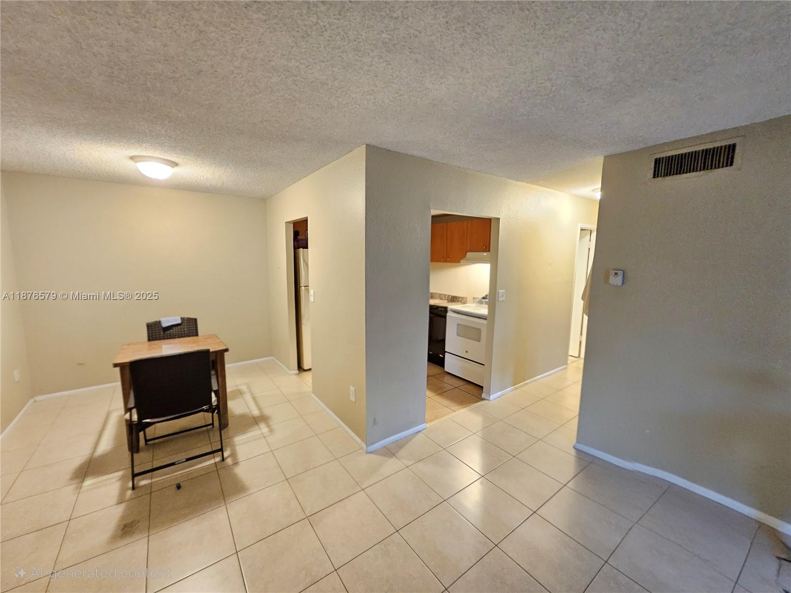 An interior view shows a dining area with tile flooring leading into a kitchen — 411 Executive Center Dr # 209, West Palm Beach FL 33401, WEST PALM BEACH, FL