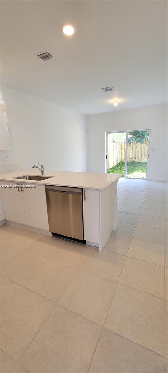 A kitchen island with a stainless steel dishwasher and sink sits on a tiled floor — 1010 SE 26th Ter, Homestead FL 33035, HOMESTEAD, FL