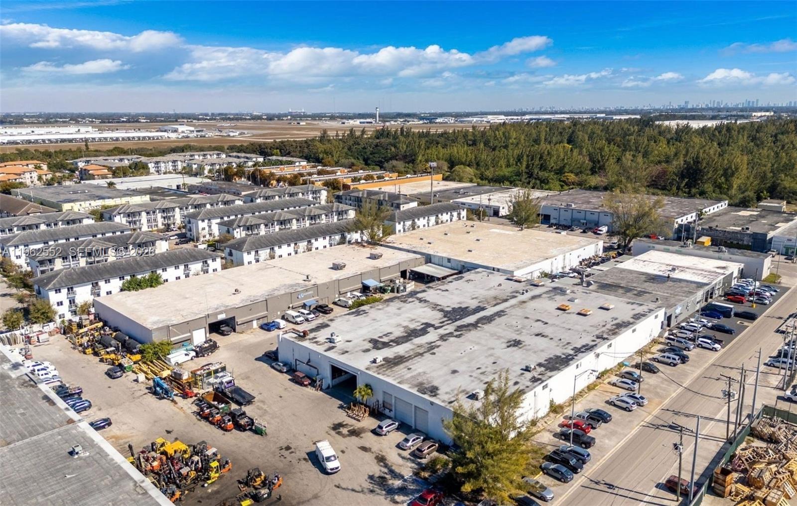 An aerial view shows industrial warehouse buildings with parking lots and surrounding residential complexes — 215 W 75th Pl Unit A, Hialeah FL 33014, HIALEAH, FL