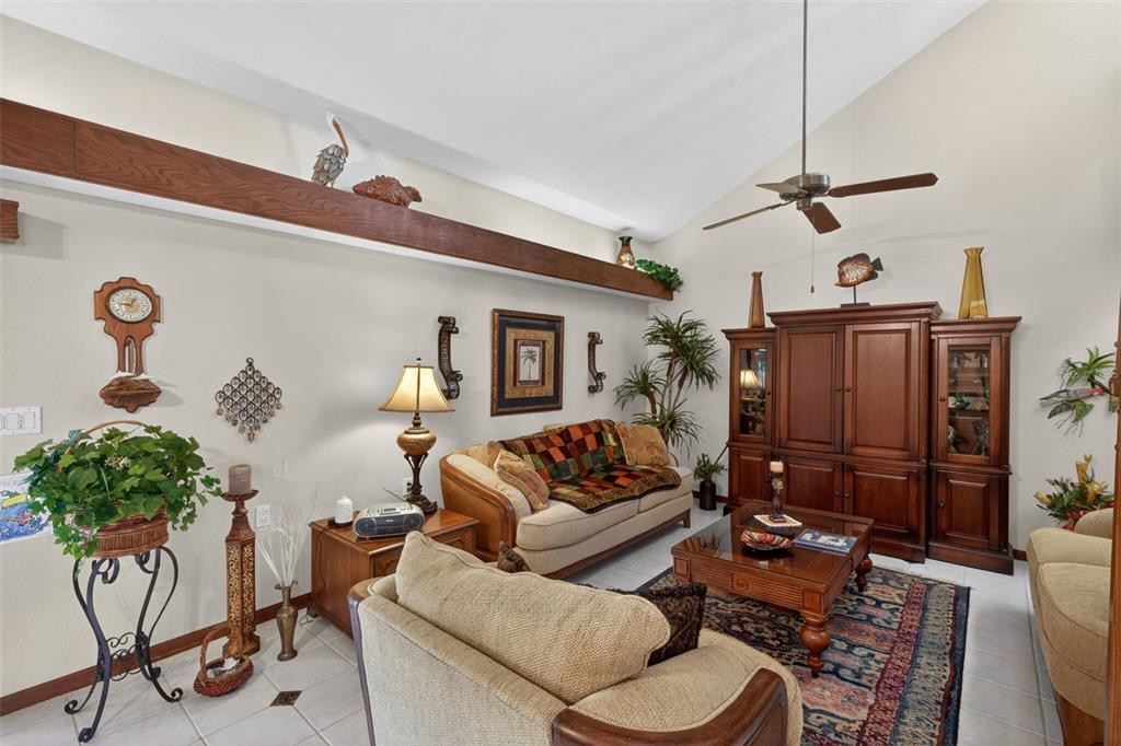 A living room features a vaulted ceiling, a wooden beam, and traditional furniture — 6072 HUNTINGTON WOODS DRIVE UNIT 17, NAPLES, FL