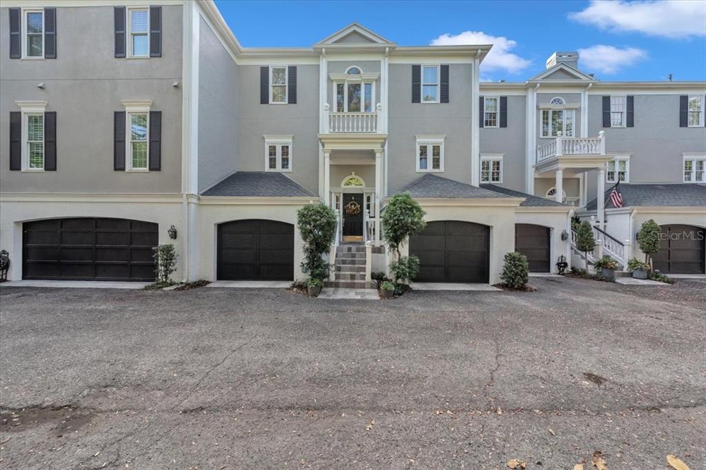 A multi-story townhouse exterior features gray siding, black garage doors, and a central entryway — 6212 BAYSHORE BOULEVARD UNIT K, TAMPA, FL