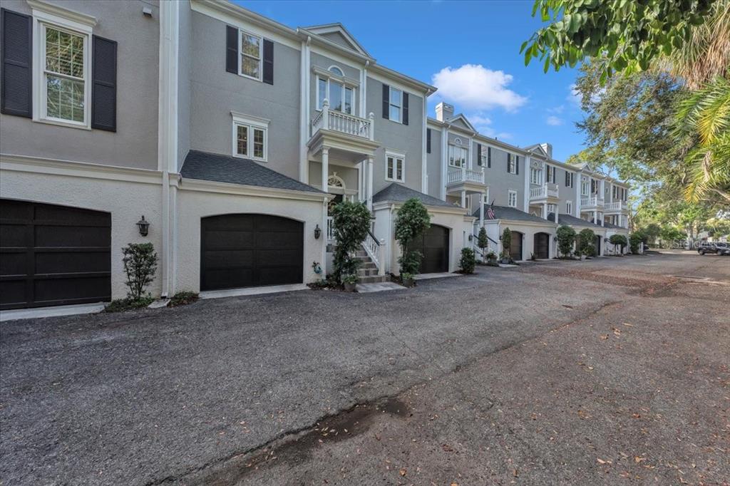 A row of multi-story townhouses with gray siding, black garage doors, and small balconies — 6212 BAYSHORE BOULEVARD UNIT K, TAMPA, FL