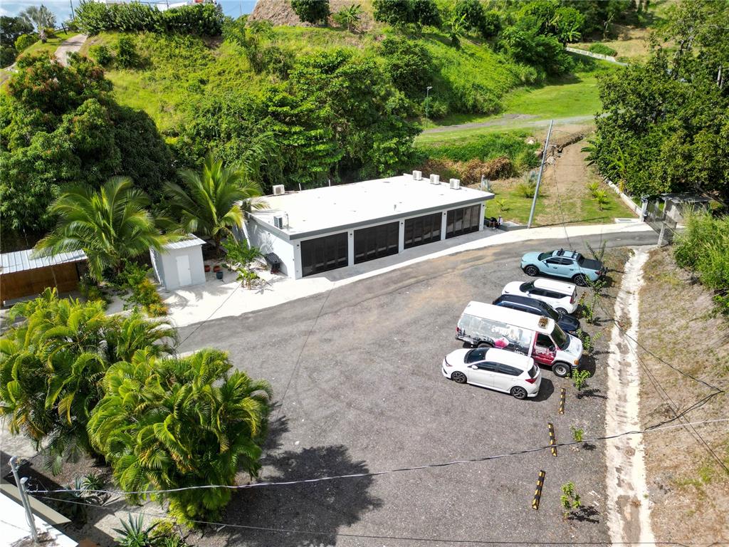 An aerial view shows a flat-roofed building with multiple garage doors and a paved parking lot — 348 CAMINO JUAN LEBRON, MAYAGUEZ, PR