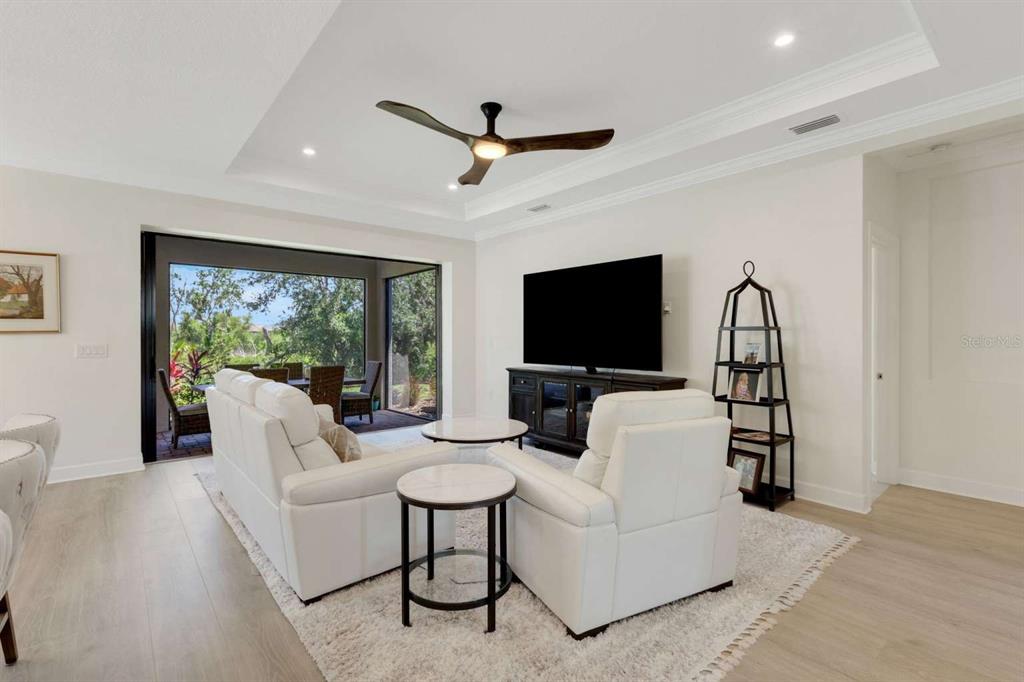 A living room features white leather furniture, a dark wood media console, and a ceiling fan — 5410 MOREY FARMS LOOP, PALMETTO, FL