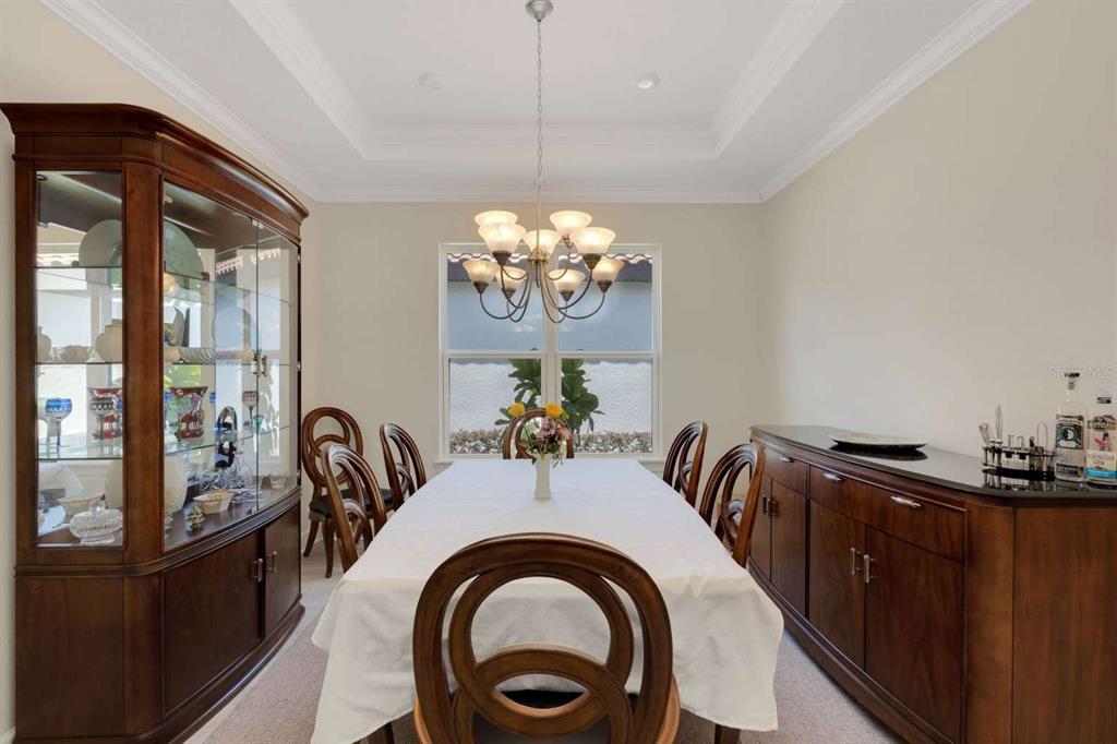 A formal dining room features a wooden table, chairs, a china cabinet, and a sideboard — 5410 MOREY FARMS LOOP, PALMETTO, FL