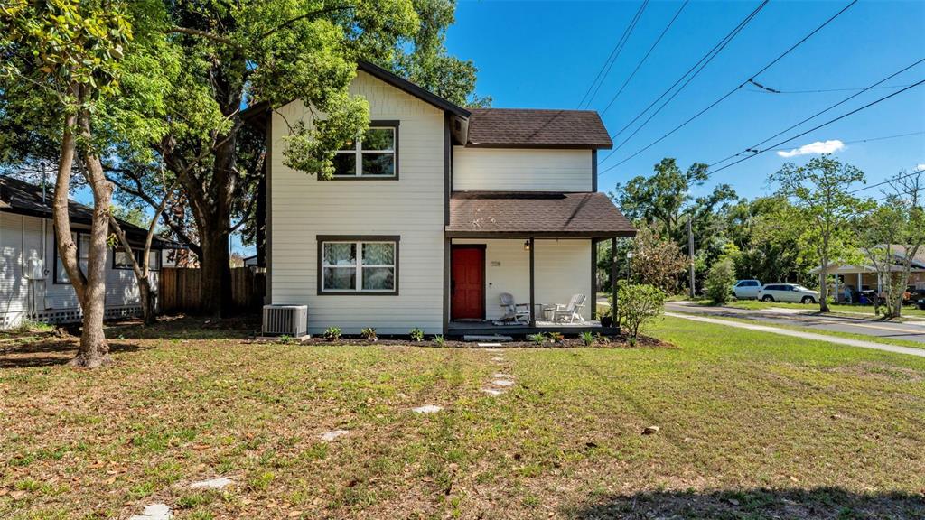 A two-story house with white siding, a brown roof, and a red front door — 728 W BELMAR STREET, LAKELAND, FL