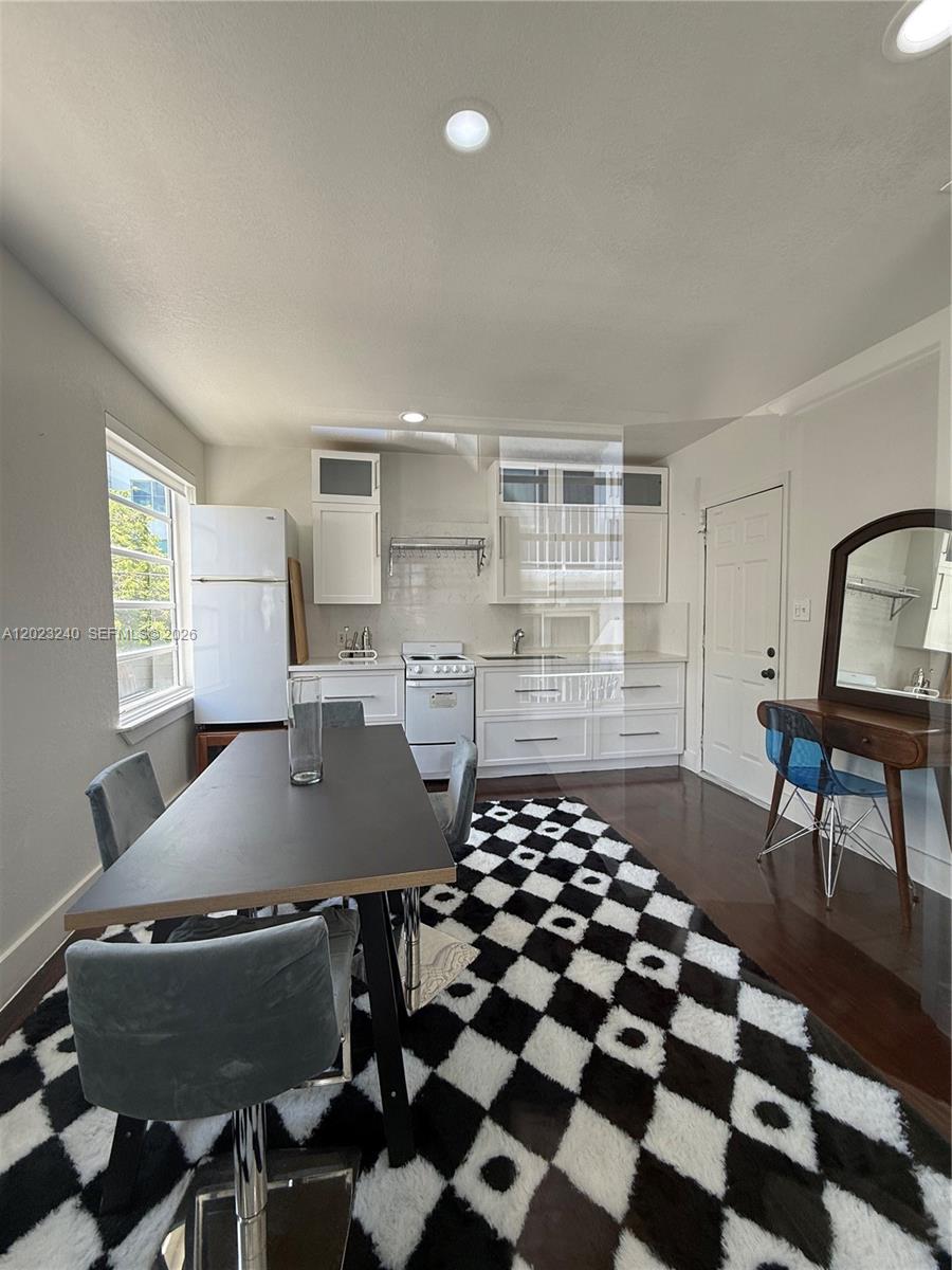 A kitchen and dining area features white cabinets, a black-and-white checkered rug, and a dining table — 723 2nd St # 8, Miami Beach FL 33139, MIAMI BEACH, FL