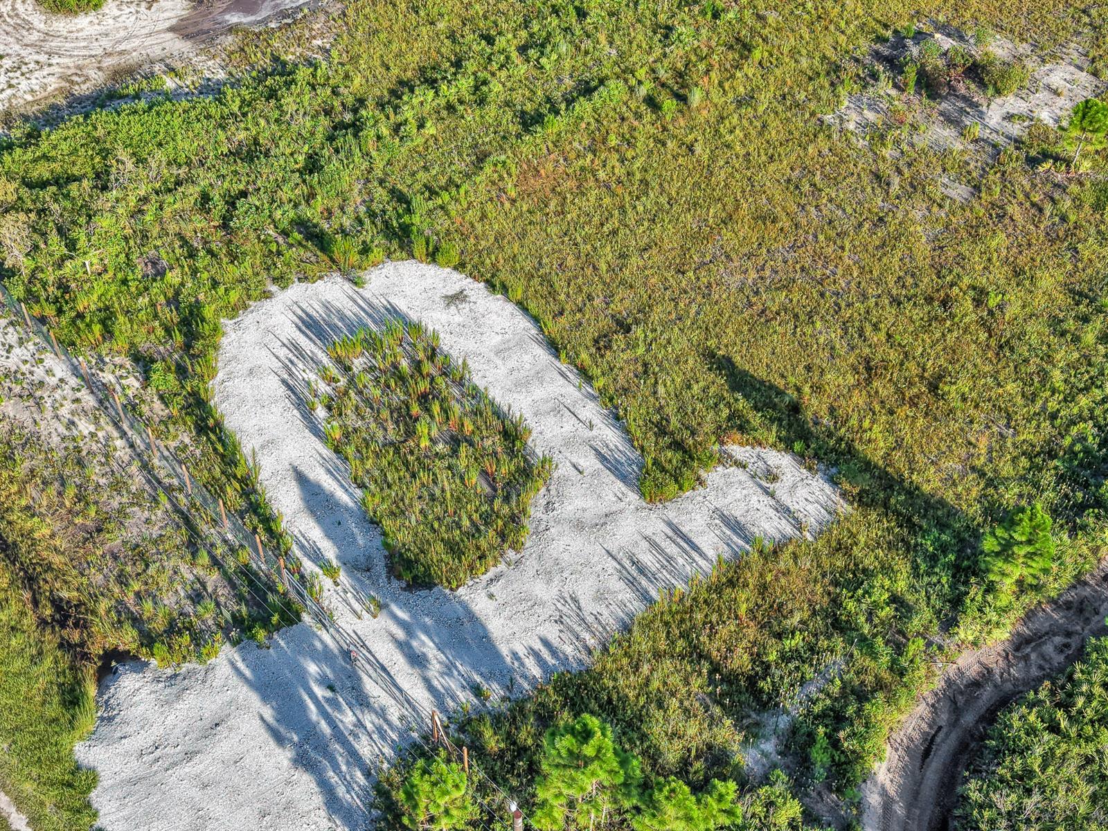 An aerial view shows a cleared, U-shaped gravel area surrounded by low-lying green vegetation — 22184 NW 278th Street, Okeechobee FL 34972, OKEECHOBEE, FL