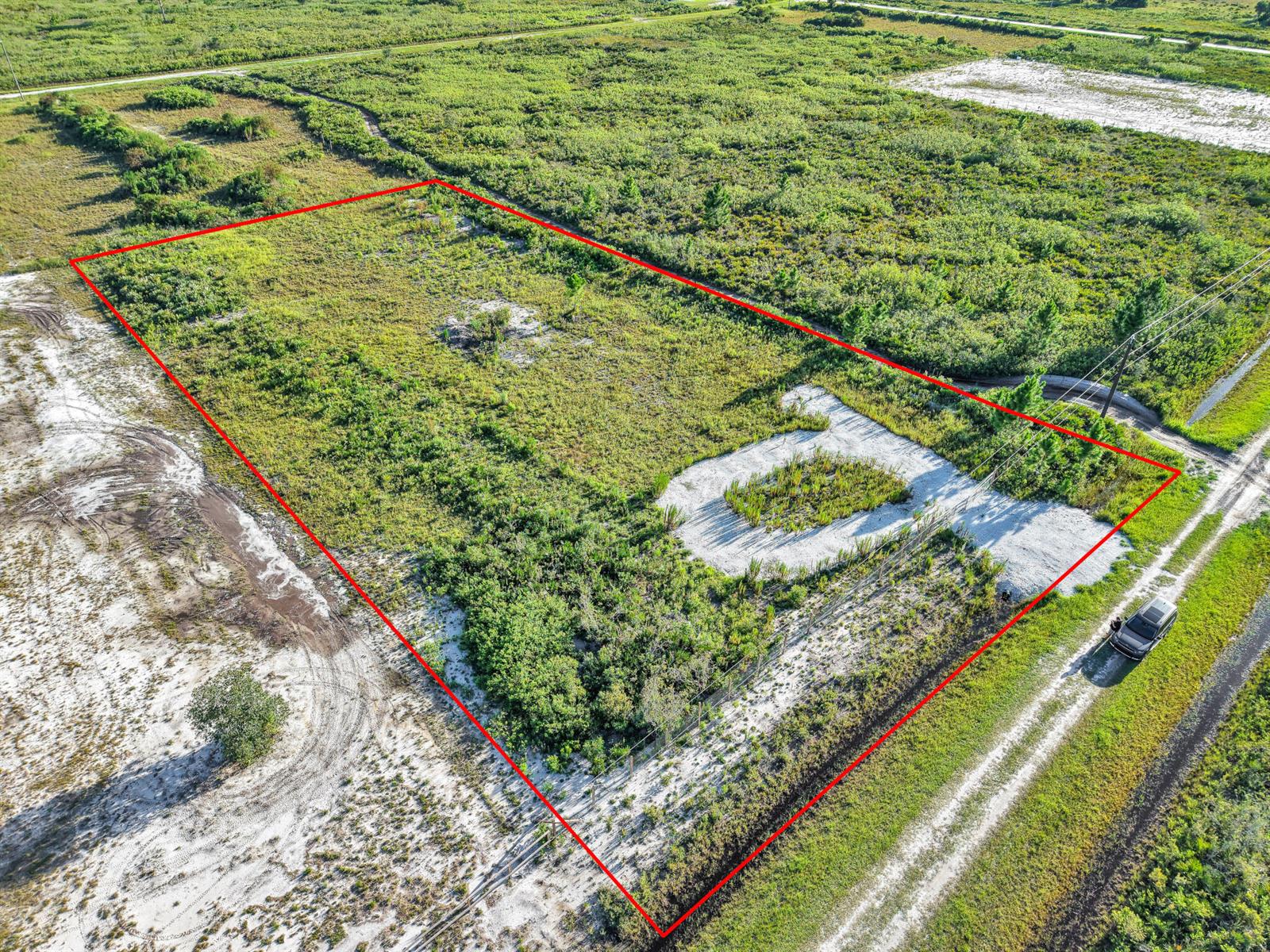 An aerial view shows a rectangular plot of undeveloped land outlined in red — 22184 NW 278th Street, Okeechobee FL 34972, OKEECHOBEE, FL