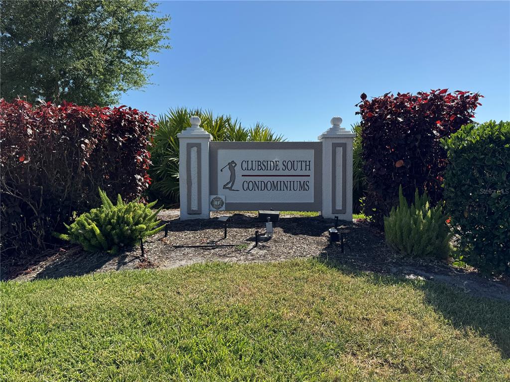 A sign for Clubside South Condominiums stands in a landscaped area with bushes and grass — 9630 CLUB SOUTH CIRCLE UNIT 6209, SARASOTA, FL