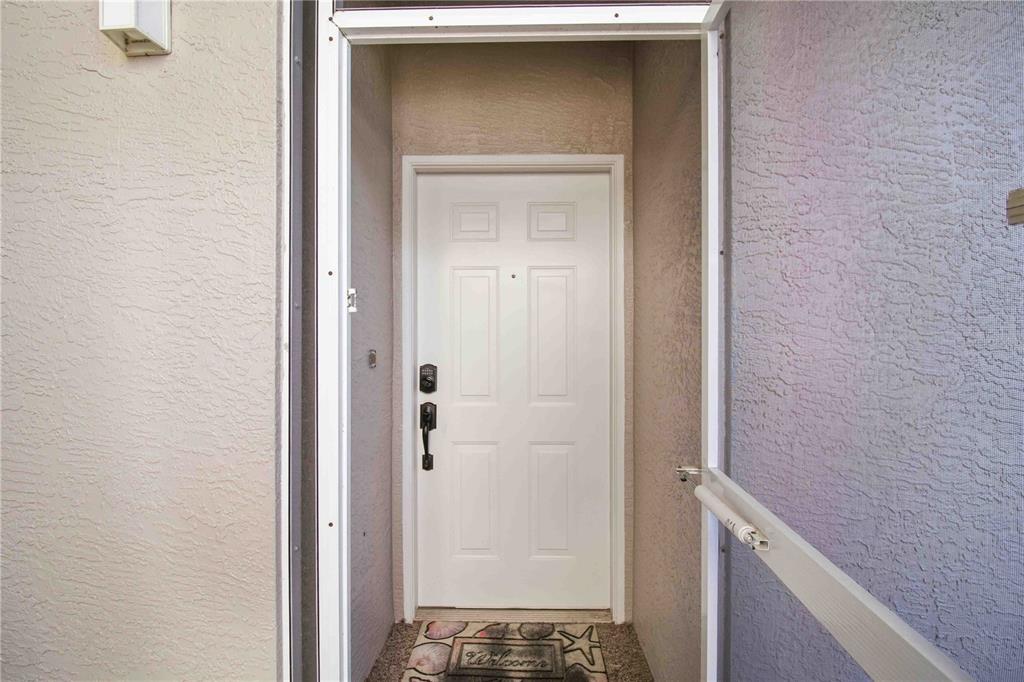 A white front door with a smart lock is framed by a screen door — 9630 CLUB SOUTH CIRCLE UNIT 6209, SARASOTA, FL