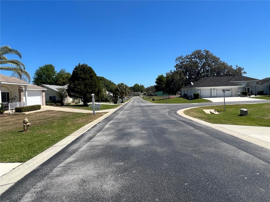 A residential street view features houses, lawns, a fire hydrant, and a clear blue sky — 5333 NW 25TH LOOP, OCALA, FL