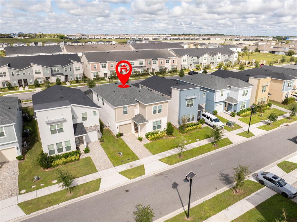 An aerial view shows a two-story suburban house with a gray roof and tan siding — 2358 SALTY WINDS WAY, KISSIMMEE, FL