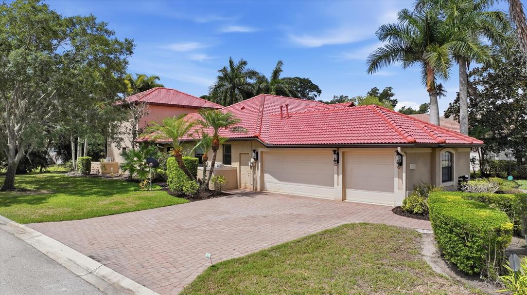 A tan house with a red tile roof and a brick driveway — 3754 EAGLE HAMMOCK DRIVE, SARASOTA, FL