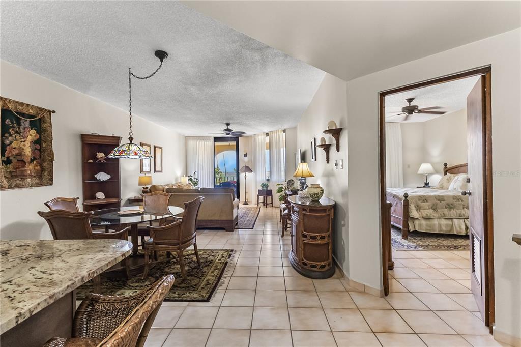 A living and dining area with tile floors leads to a bedroom through an open doorway — 190 CANDELERO DR UNIT 228, HUMACAO, PR