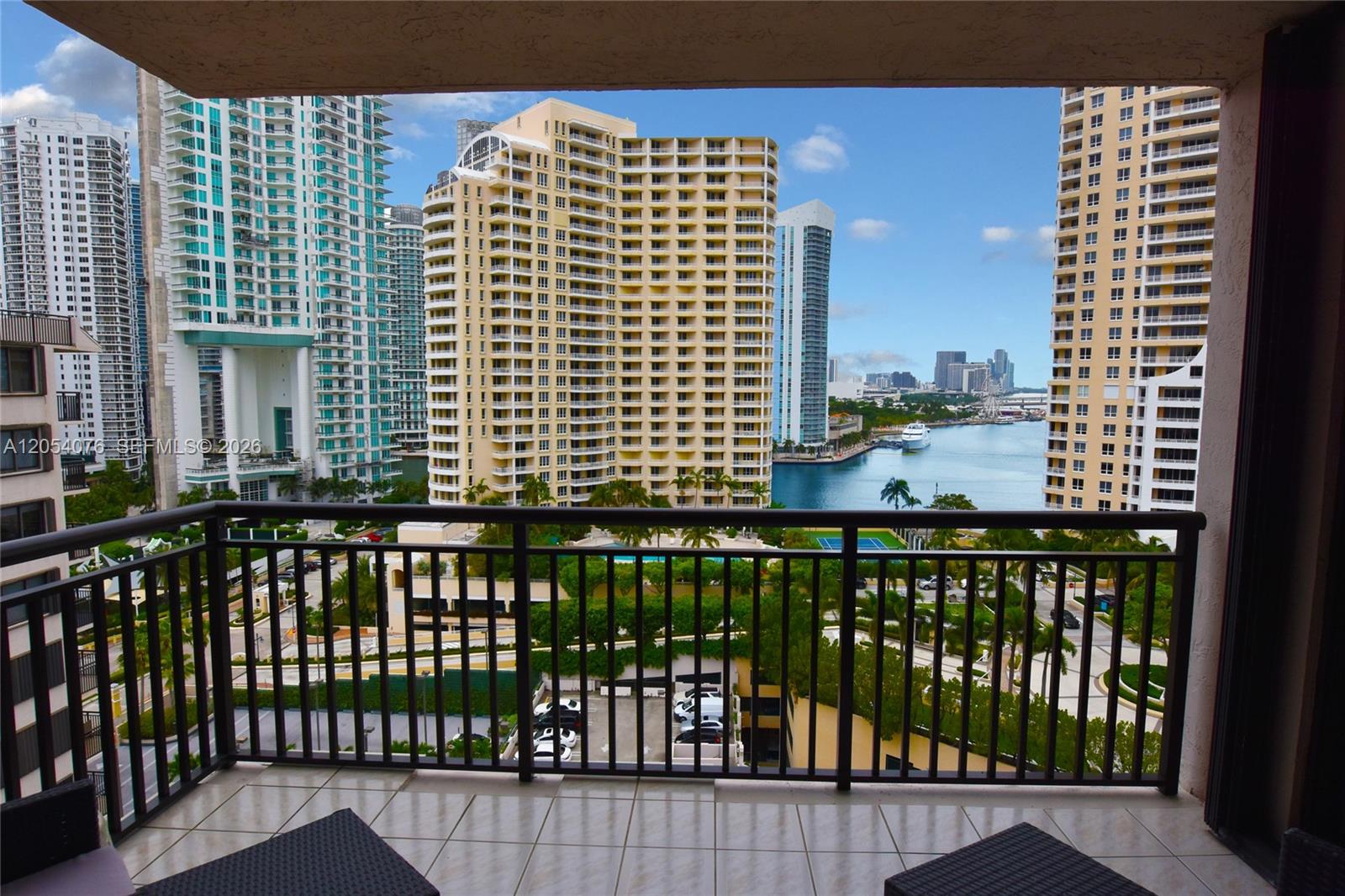 A balcony with a metal railing overlooks a waterfront view of high-rise apartment buildings — 540 Brickell Key Dr # 1414, Miami FL 33131, MIAMI, FL