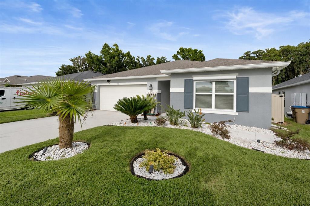 A single-story gray house with a two-car garage and landscaped front yard — 4521 CASABLANCA AVENUE, KISSIMMEE, FL