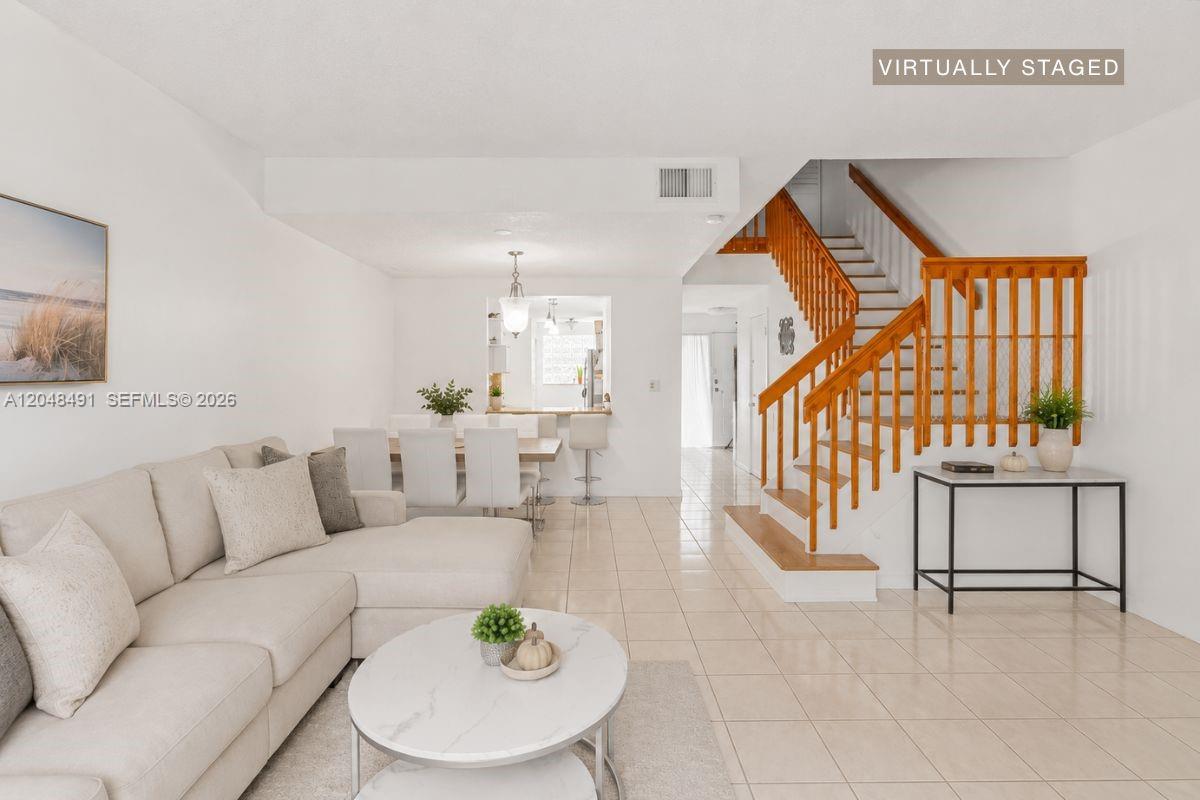 This living room features a sectional sofa, a dining area, and a wooden staircase — 10014 Hammocks Blvd # 4, Miami FL 33196, MIAMI, FL