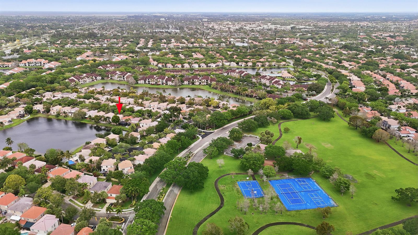 An aerial view shows a residential neighborhood with a lake, tennis courts, and green space — 10690 NW 12th Drive, Plantation FL 33322, PLANTATION, FL
