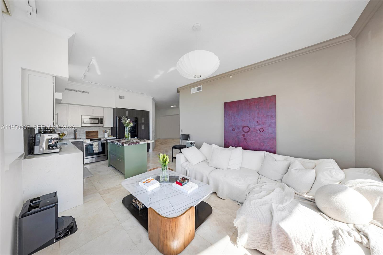 A modern open-concept living room features a white sectional sofa, marble coffee table, and kitchen — 1745 E Hallandale Beach Blvd # 2407W, Hallandale Beach FL 33009, HALLANDALE BEACH, FL