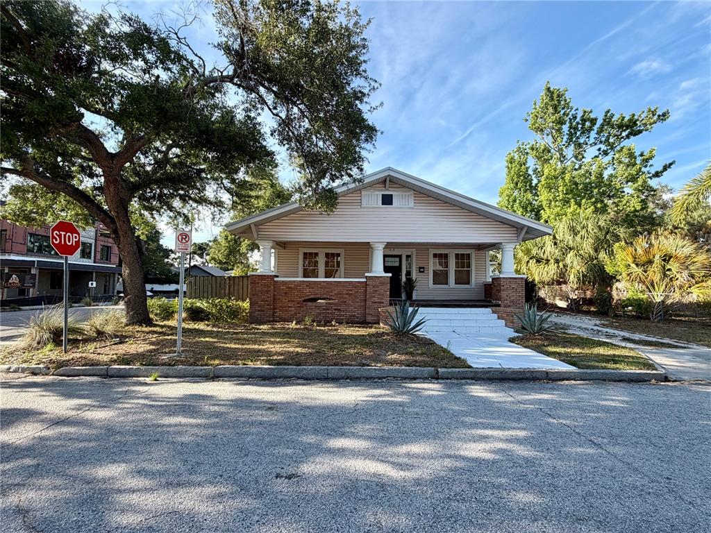 A single-story house with a brick porch base, white siding, and a front-facing gable roof — 419 W PARK AVENUE, TAMPA, FL