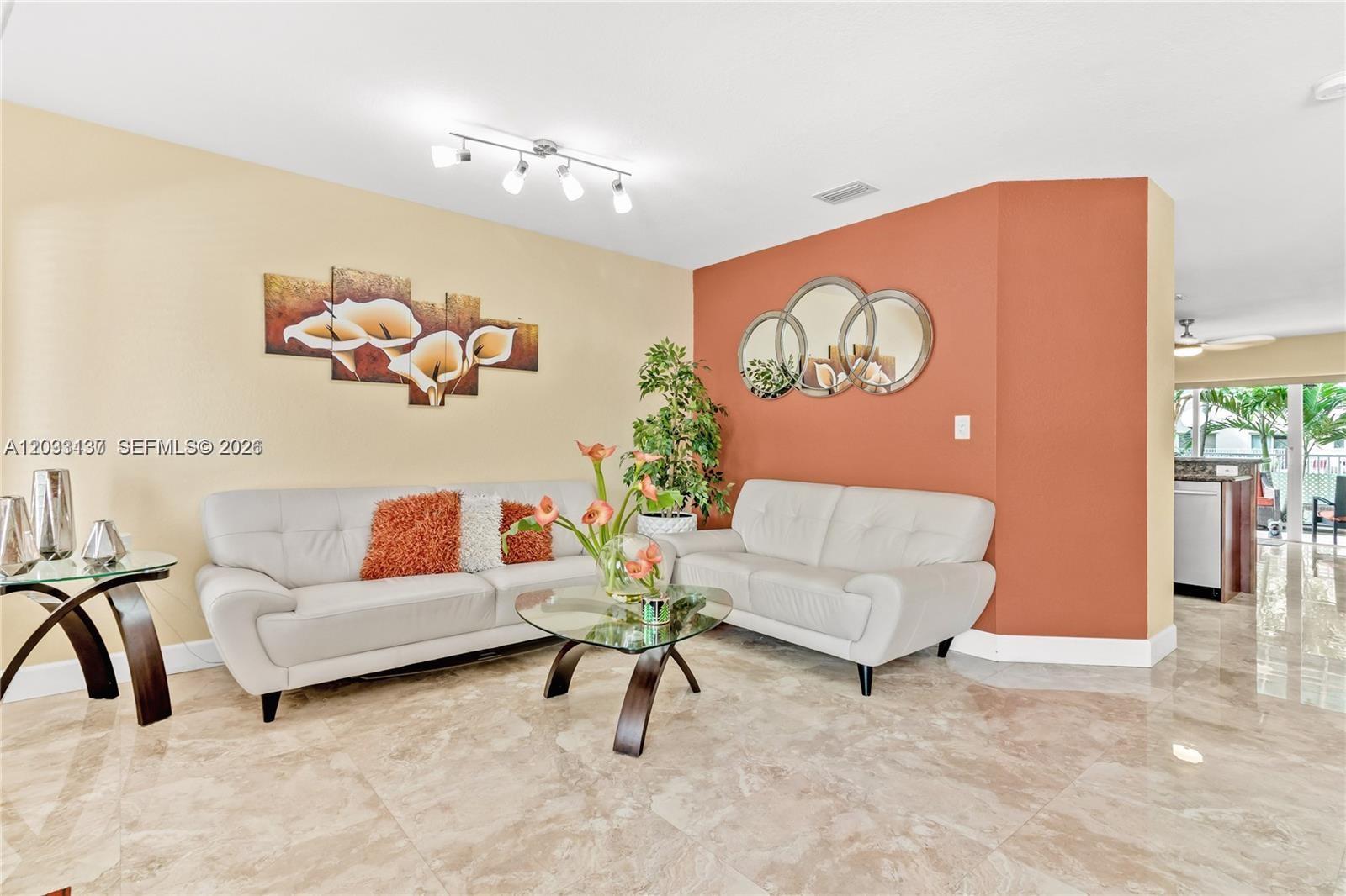 A living room features two white sofas, a glass coffee table, and two-toned walls — 16453 SW 97th St # 0, Miami FL 33196, MIAMI, FL