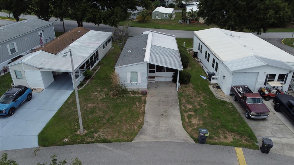 An aerial view shows three single-story manufactured homes with driveways and parked vehicles — 50989 HIGHWAY 27 UNIT 33, DAVENPORT, FL