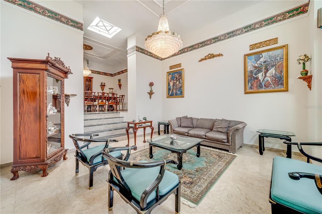 A formal living room features a crystal chandelier, marble floors, and a raised dining area — Cll 1 STREET UNIT 602, GUAYNABO, PR
