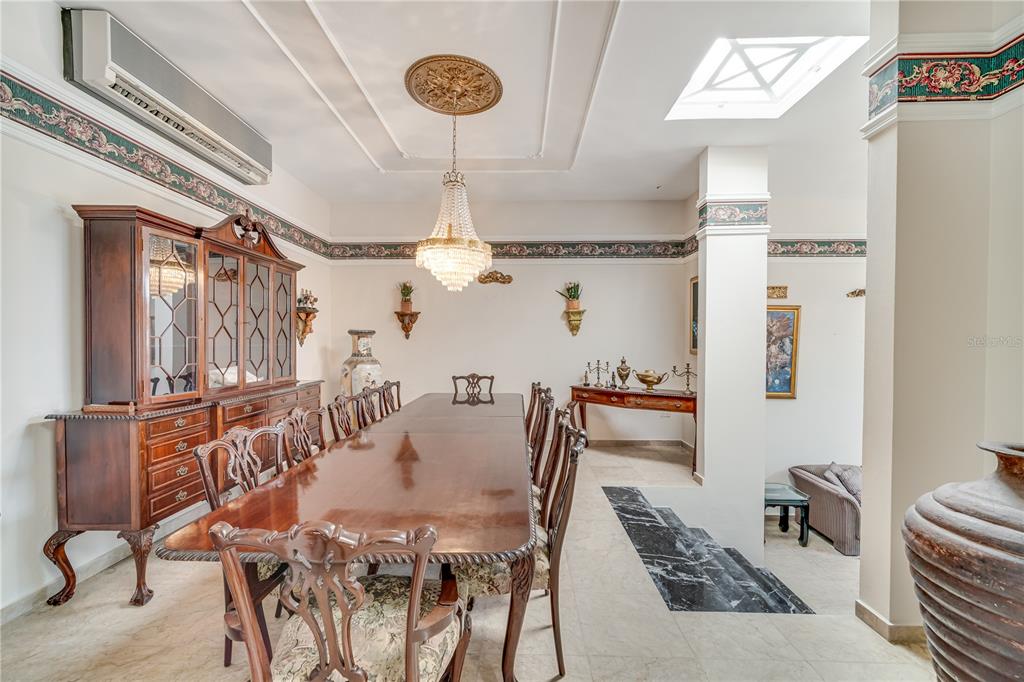 A formal dining room features a long wooden table, a crystal chandelier, and a hutch — Cll 1 STREET UNIT 602, GUAYNABO, PR