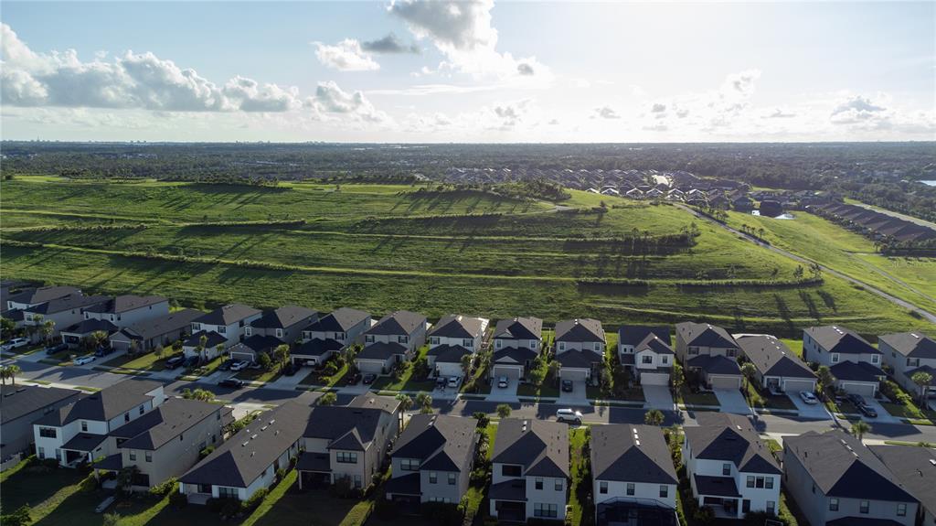 An aerial view shows a suburban neighborhood situated next to a large, terraced grassy hill — 6378 GRANDVIEW HILL COURT, BRADENTON, FL