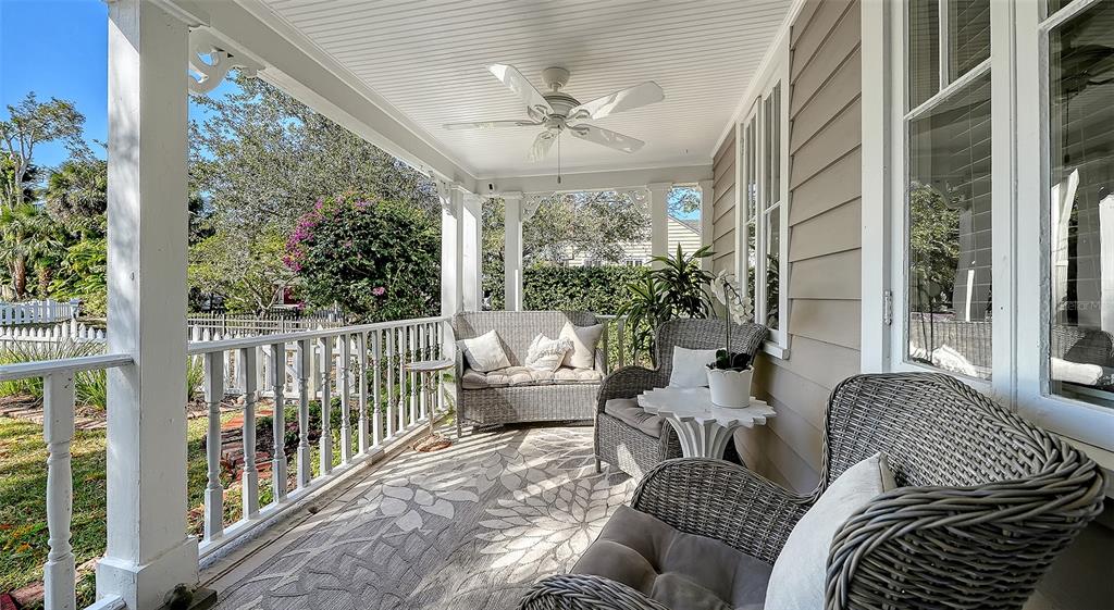 A covered porch features wicker furniture, a ceiling fan, and a white railing — 1751 FLOYD STREET, SARASOTA, FL