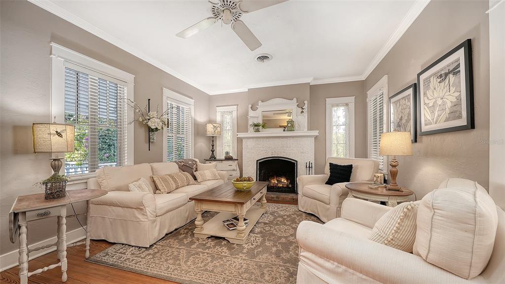 A living room features a fireplace, white sofas, a coffee table, and a ceiling fan — 1751 FLOYD STREET, SARASOTA, FL