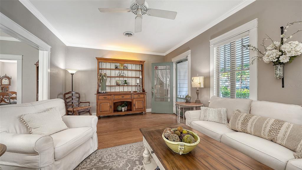 A living room features two white sofas, a wooden hutch, and a coffee table — 1751 FLOYD STREET, SARASOTA, FL