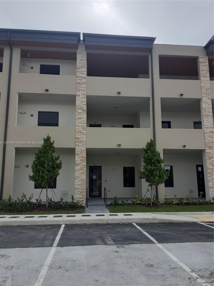 This is an exterior view of a three-story apartment building with stone-accented pillars — 8175 NW 104th Ave # 35, Doral FL 33178, DORAL, FL