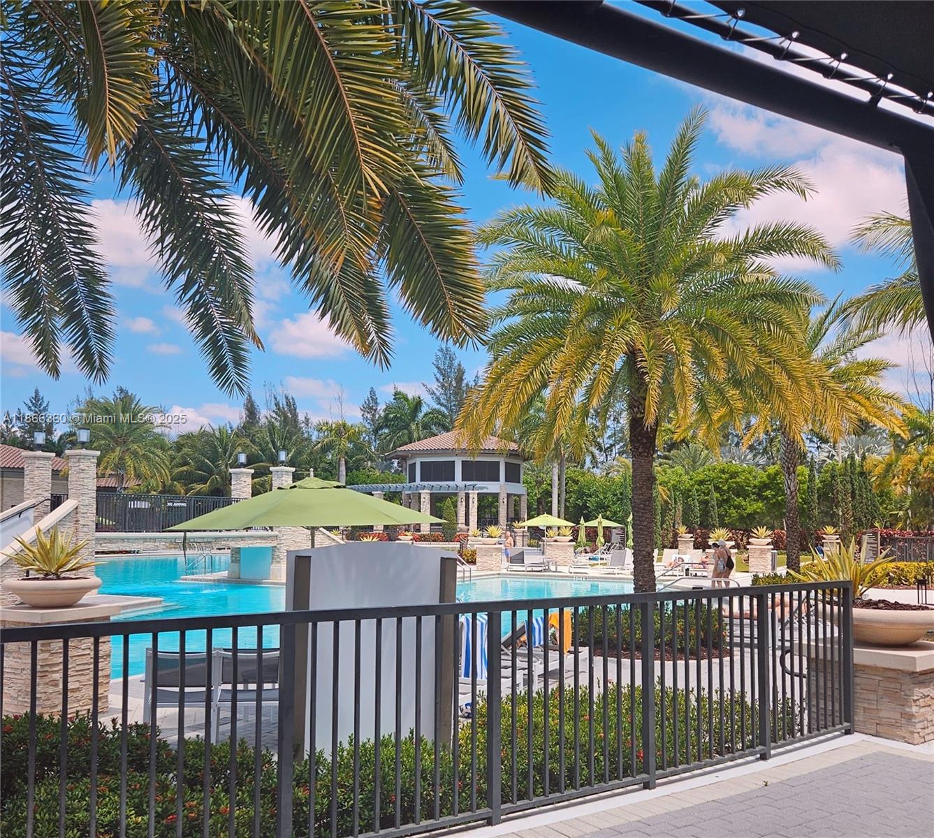 A swimming pool area features palm trees, a gazebo, lounge chairs, and a metal fence — 8175 NW 104th Ave # 35, Doral FL 33178, DORAL, FL