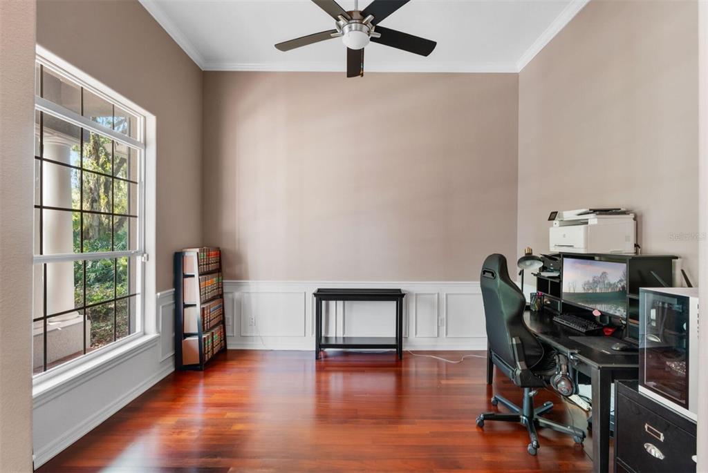 A home office with hardwood floors, a large window, wainscoting, and a ceiling fan — 2304 INDIAN MOUND TRAIL, KISSIMMEE, FL