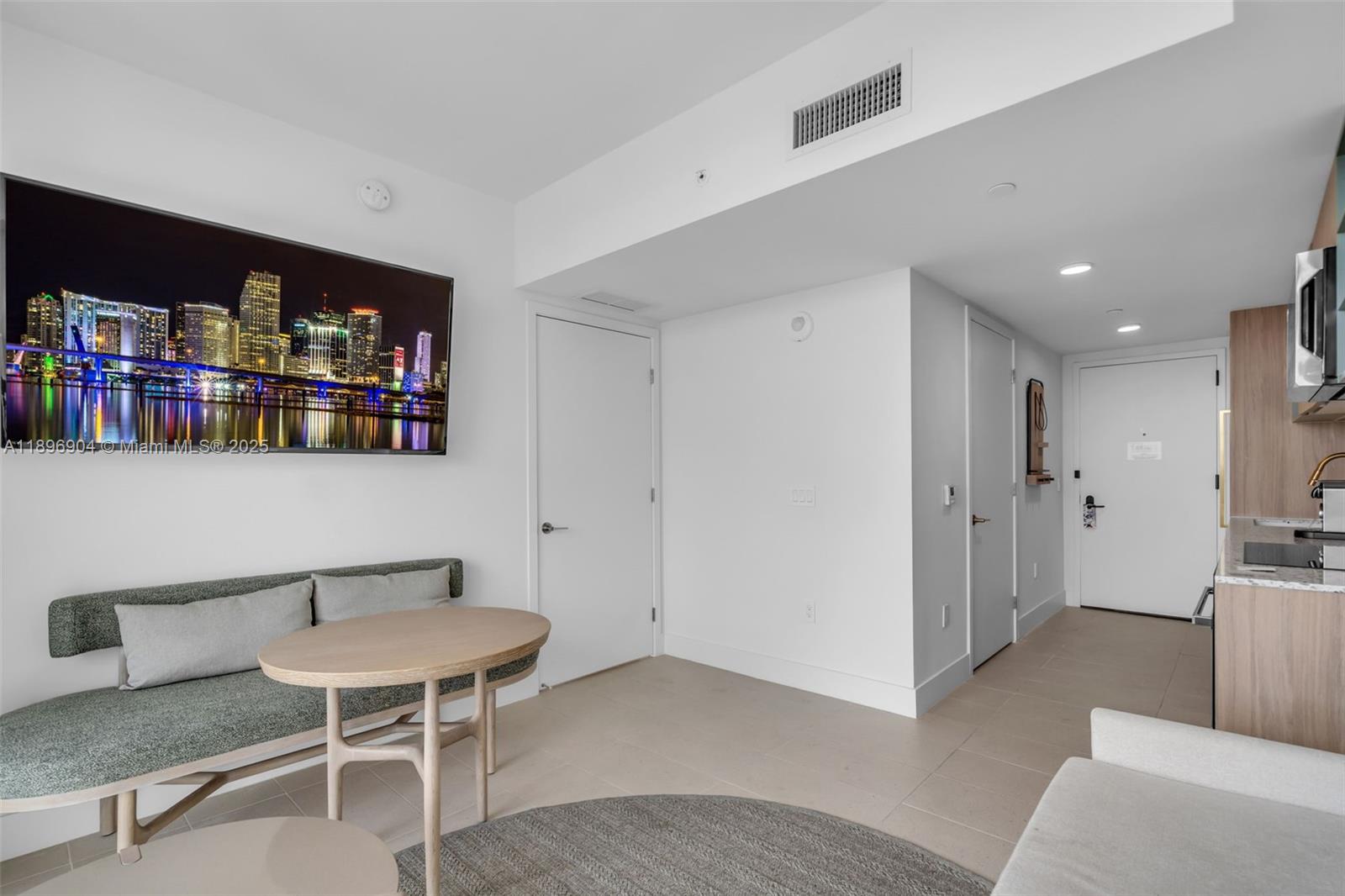 This room features a dining nook with a bench, a television, and a kitchenette — 159 NE 6th St # 4514, Miami FL 33132, MIAMI, FL
